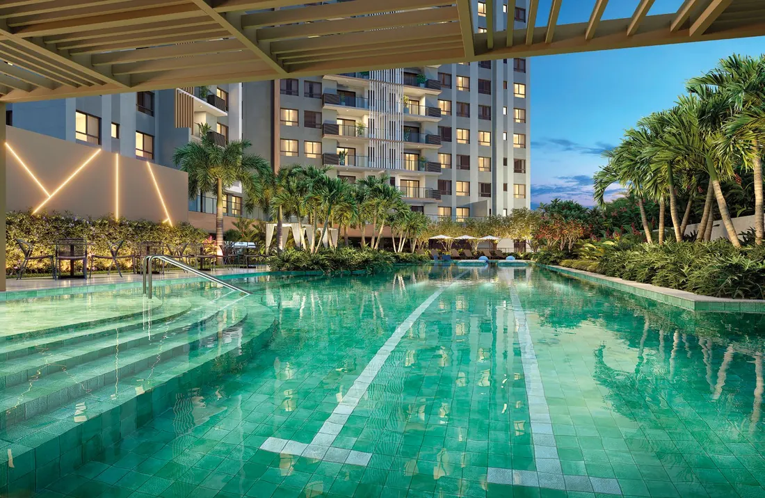 Piscina adulto com raia de 25 m do Epic Golf Residence, cercada de palmeiras